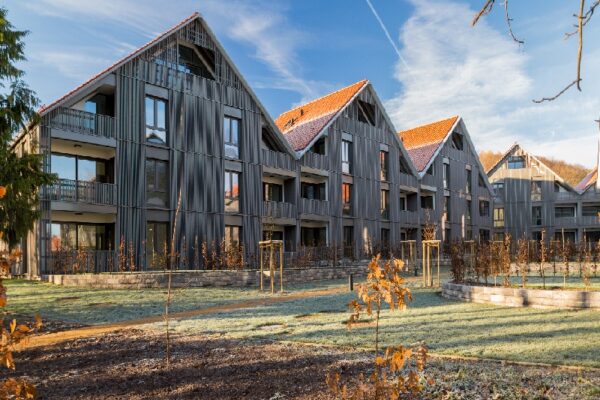 Blick auf ein Neubaukomplex mit blauem Himmel und Holzfassade