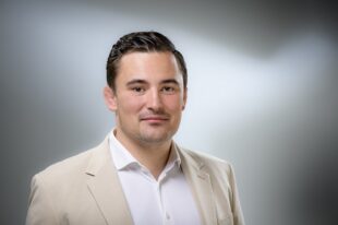 Porträt von Georg Dismer, Junior Consultant Immobilien der GLC AG, in weißem Hemd und beigen Blazer