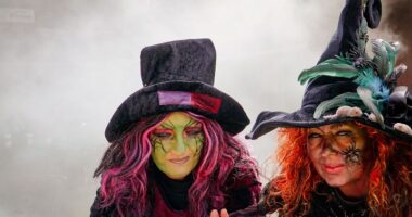 Frauen als Hexen verkleidet über dem "Hexenkessel" mit Neben im Hintergrund
